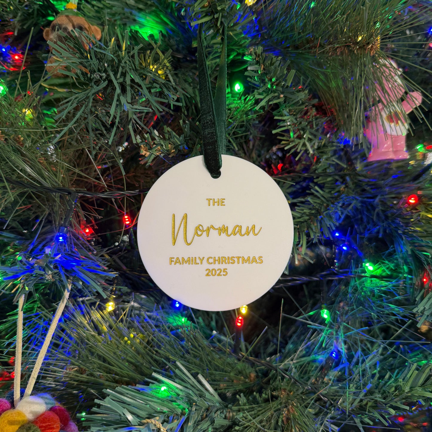 Decorative ornament with 'The Norman Family Christmas' text on a Christmas tree.